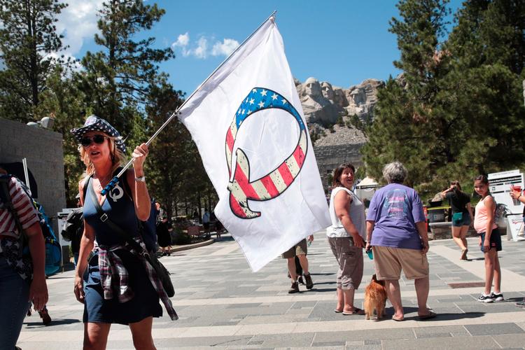 Trump-tilhængere med Q-fanen på vej til vælgermøde 3. juli. Flere tilhængere af QAnon og konspirationsteorier har gode chancer for at blive valgt til Kongressen i november, og de skal bære Donald Trump videre i valgkampen. Foto: Scott Olson/Ritzau Scanpix