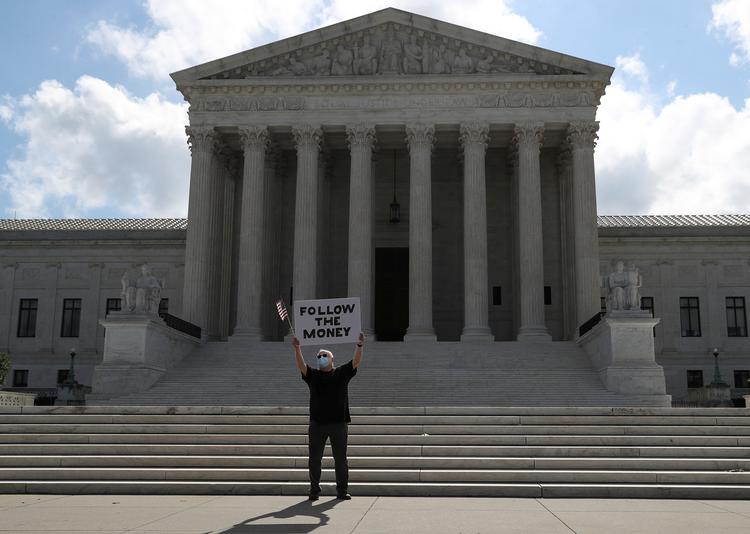 En demonstrant er mødt op foran Højesteret med et skilt, der siger, hvad han mener.  Foto: Leah Millis/Ritzau Scanpix