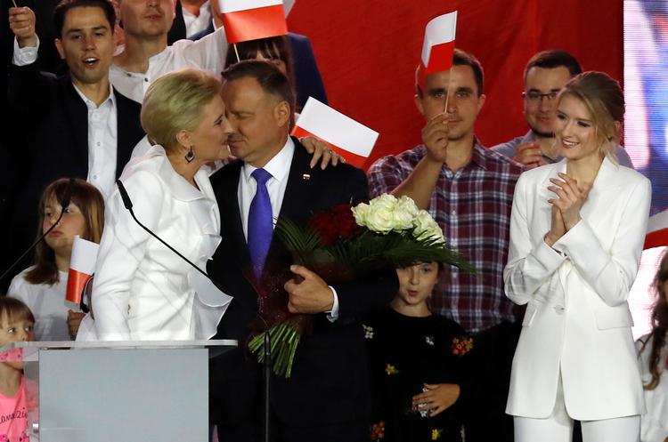 Præsident Andrzej Duda får kys fra hustruen Agata og applaus fra datteren Kinga under en tale til sine tilhængere i aftes. Foto: Kacper Pempel/Ritzau Scanpix