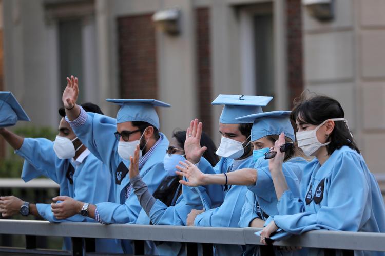 Arkitekt-studerende fejrer deres afsluttende eksamen på Columbia University i New York med at vinke til forbipasserende. Foto: Andrew Kelly/Ritzau Scanpix