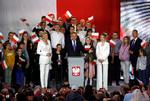 Polens siddende præsident, Andrzej Duda, taler stående mellem sin hustru, Agata Kornhauser-Duda, og deres datter, Kinga Duda, på valgaftenen.   Foto: Kacper Pempel/Ritzau Scanpix