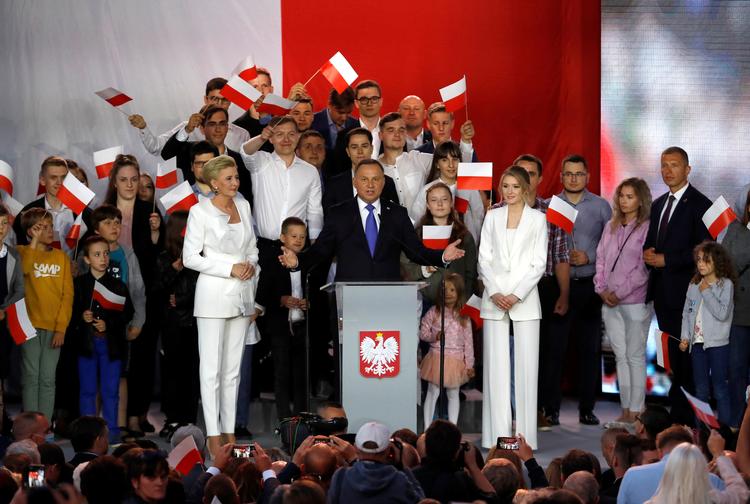 Polens siddende præsident, Andrzej Duda, taler stående mellem sin hustru, Agata Kornhauser-Duda, og deres datter, Kinga Duda, på valgaftenen.   Foto: Kacper Pempel/Ritzau Scanpix