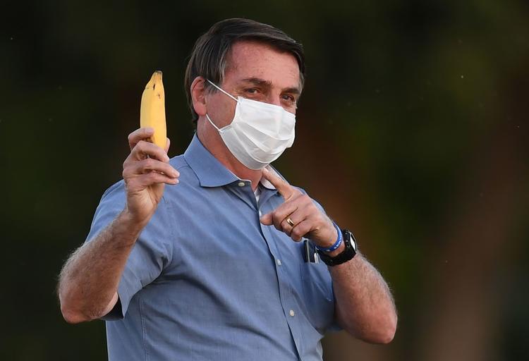 Jair Bolsonaro, som af uransagelige årsager her viser en banan frem, har på twitter meddelt, at hans seneste coronatest er negativ. Foto: Evaristo Sa/Ritzau Scanpix
