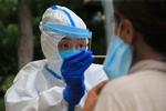 En sundhedsmedarbejder tester en person for coronavirus i Dalian, der ligger i Kinas nordøstlige provins Liaoning. Foto: Str/Ritzau Scanpix