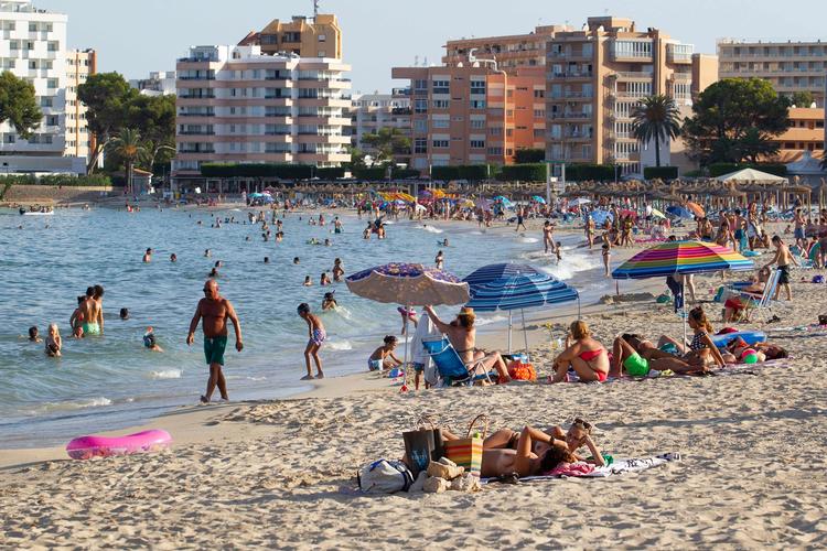 Turister nyder varmen og vandet på Palmanova Beach på øen Mallorca. Britiske turister frarådes nu at besøge øen. De spanske øer var ellers ikke i første omgang omfattet af de skærpede rejserestriktioner, som de britiske myndigheder indførte for fastlands-Spanien tidligere mandag. Foto: Jaime Reina/Ritzau Scanpix
