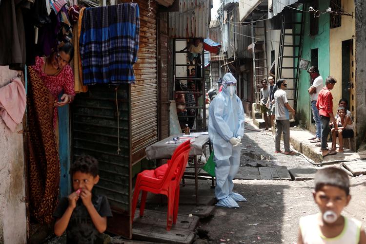 En sundhedsarbejder med beskyttelsesudstyr tester lokale i et af Mumbais fattige kvarterer. En undersøgelse viser, at mange fra byens slumkvarterer er smittet med coronavirus.  Foto: Francis Mascarenhas/Ritzau Scanpix