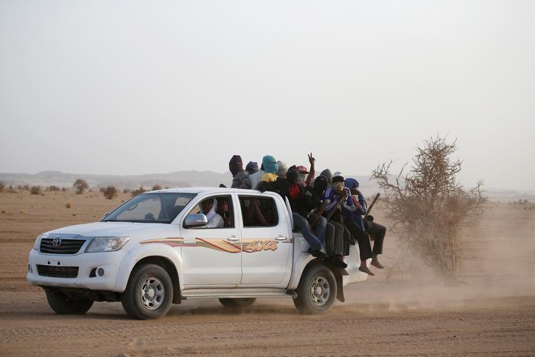 Næsten en tredjedel af dødsfaldene på land sker, når migranterne forsøger at krydse Sahara-ørkenen. Det sker typisk stuvet sammen på ladet af pickup-biler, der kører med fuld fart gennem ørkenen med en menneskesmugler bag rattet. Jævnligt falder migranter af i farten og efterlades i ørkenen. Foto: Joe Penney/Ritzau Scanpix