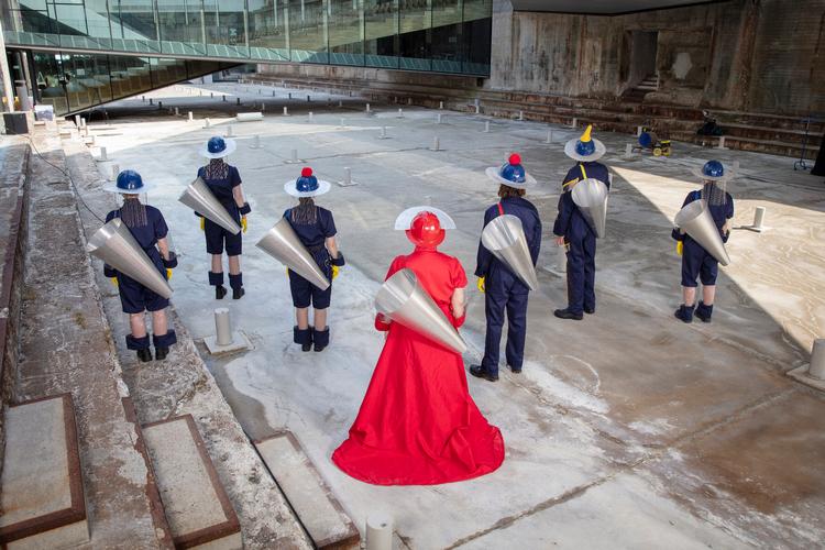 En brysk kvinde i rødt og hendes strikse arbejdsledere dirigerer publikum rundt i den gamle tørdok.  Foto: Vontrapp