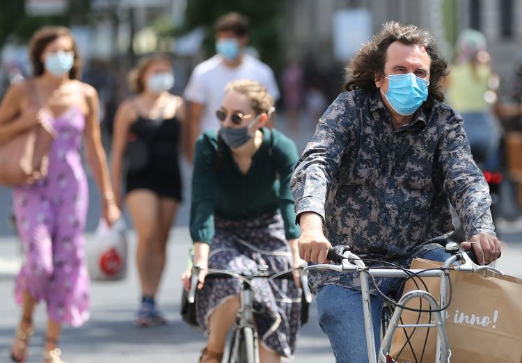 Cyklister bærer mundbind på en gade i Antverpen. Belgien har indtil videre registreret  9859 dødsfald, og det er blandt de højeste i verden, når man holder det op med Belgiens indbyggertal. Foto: Francois Walschaerts/Ritzau Scanpix