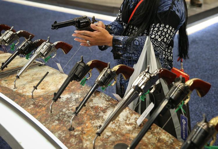 En kvinde ser på skydevåben i Kay Bailey Hutchison Convention Center under NRA's årlige konference. Ledere i National Rifle Association anklages for at have taget over 400 millioner kroner til privat forbrug. Foto: Loren Elliott/Ritzau Scanpix