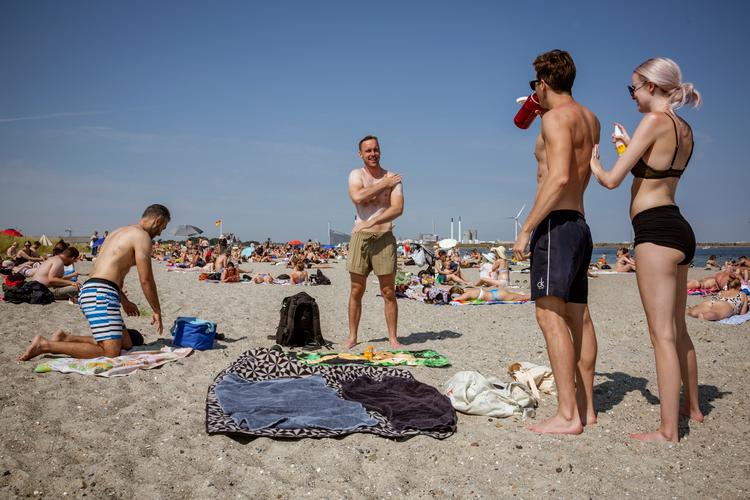 På Amagerstrand står vennegruppen Martin Sørensen, Elias Obeid, Amanda Madsen og Alexander Johansen på skoleferiens næstsidste fridag og nyder solen, ligesom rigtig mange andre var. Foto: Miriam Dalsgaard/POLFOTO