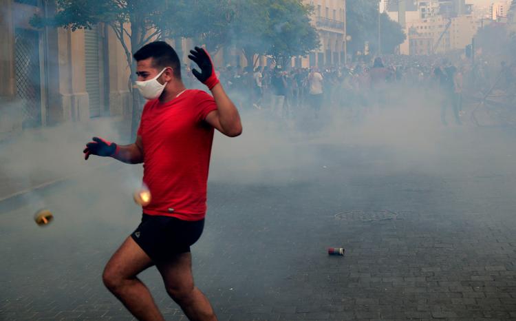 En libanesisk demonstrant flygter i sikkerhed, efter at der er blevet skud med tåregas mod demonstranterne Foto: Anwar Amro/Ritzau Scanpix
