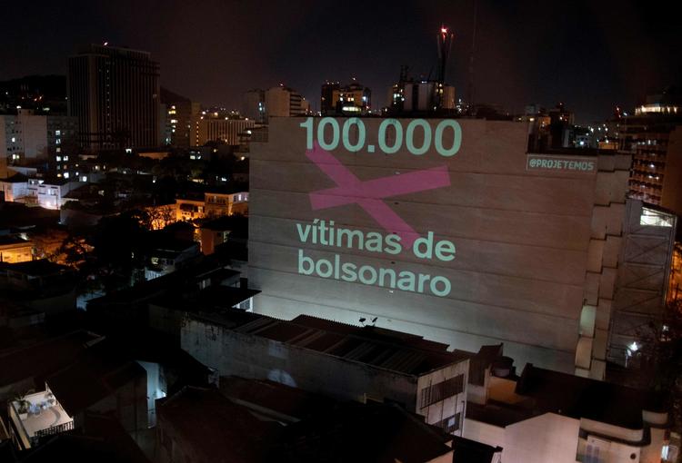 '100.000 ofre for Bolsonaro', lyder en projektion på en bygning i Rio de Janeiro. Brasiliens præsident, Jair Bolsonaro, kritiseres for sin afslappede tilgang til coronavirussen, som nu har kostet 100.000 brasilianere livet. Foto: Mauro Pimentel/Ritzau Scanpix