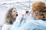 Borgerne i Frydenlund stod i kø fra morgenstunden for at blive coronatestet. Den mobile enhed i Aarhus fik hjælp af Region Nordjyllands personale til de mange test.De kan nå mere end 500 test på dagen. Det blå team fra Nordjylland supplerer tre fra Region Midtjylland i dagens testarbejde i Frydenlund, Her bliver Susan Humle testet for corona. Foto: Helle Arensbak/Ritzau Scanpix