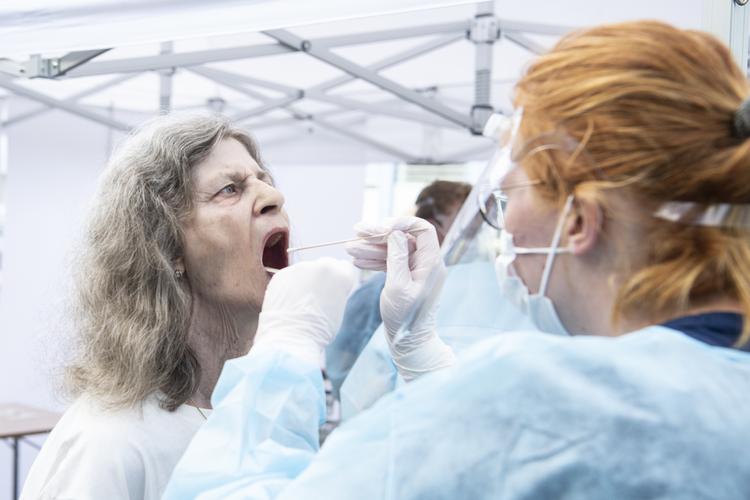 Borgerne i Frydenlund stod i kø fra morgenstunden for at blive coronatestet. Den mobile enhed i Aarhus fik hjælp af Region Nordjyllands personale til de mange test.De kan nå mere end 500 test på dagen. Det blå team fra Nordjylland supplerer tre fra Region Midtjylland i dagens testarbejde i Frydenlund, Her bliver Susan Humle testet for corona. Foto: Helle Arensbak/Ritzau Scanpix