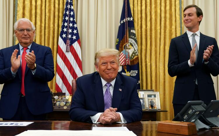 Trump har annonceret fredsaftalen i Det Hvide Hus. Til venstre står Israels ambassadør i USA, David Melech Friedman. Og til højre Trumps svigersøn og seniorrådgiver, Jared Kushner, som forhandler USA's politik i Mellemøsten. Foto: Kevin Lamarque/Ritzau Scanpix