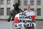 En kvinde bærer et skilt ved siden af en hviderussisk soldat. Efter landets masseanholdelser og hårde kurs mod demonstranter enes EU's udenrigsministre om sanktioner. Foto: Siarhei Leskiec/Ritzau Scanpix