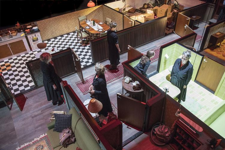 Publikum  kan se ned på fem forskellige udgaver af kvinden, som går rundt i lejligheden. Samtidig. Alle fem klædt i sort. Ens, men alligevel forskellige. Foto: Anders Bach