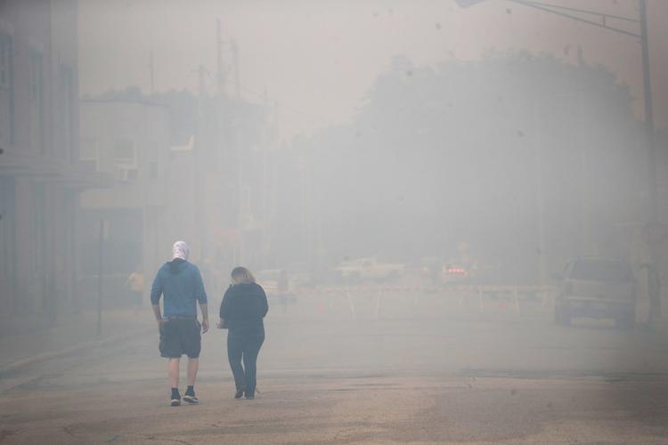 Lokale i Kenosha går i en røgfyldt gade. Store uroligheder har ramt byen, efter at politiet skød en sort mand i ryggen. Foto: Scott Olson/Ritzau Scanpix