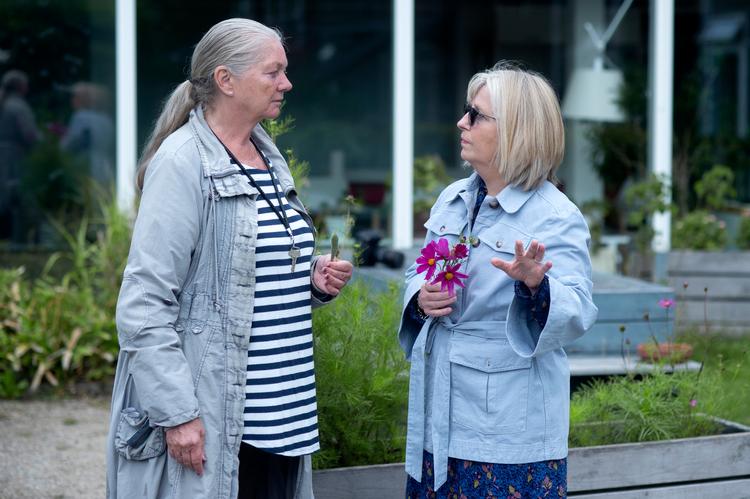 Demenskoordinator Charlotte Rugh (th.) er i haven med Sus, der er beboer på plejecentret Bakkegården i Bagsværd, for at plukke blomster.   Foto: Annika Byrde/POLFOTO