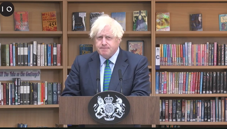 Boris Johson foran de sigende bogtitler.  Foto: Screendump fra Downing Street 10's video fra skolebesøget.