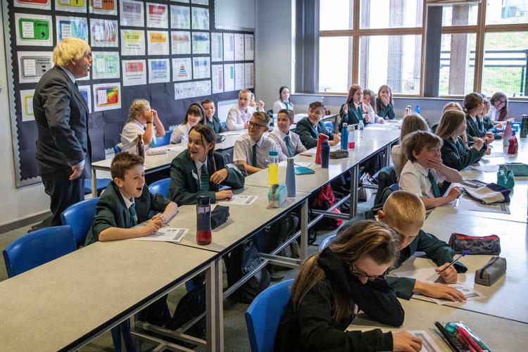 Skoleelever i England og Wales vender tilbage til klasselokalerne tirsdag under særlige coronarestriktioner. Boris Johnson ses her på besøg på Castle Rock school, på elevernes første dag tilbage i skolen i Coalville efter ferien 26 august.   Foto: Pool/Ritzau Scanpix