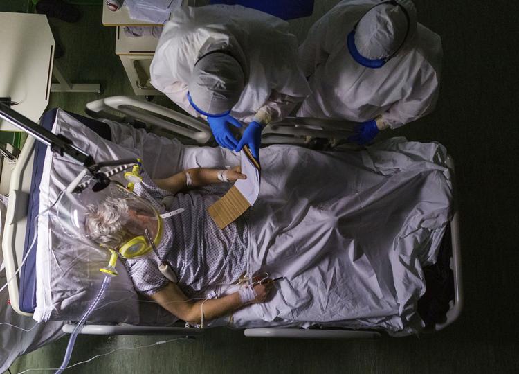 Italienske læger fotograferet i april, hvor de undersøgte en 82-årig patient for corona.  Foto: Domenico Stinellis/Ritzau Scanpix