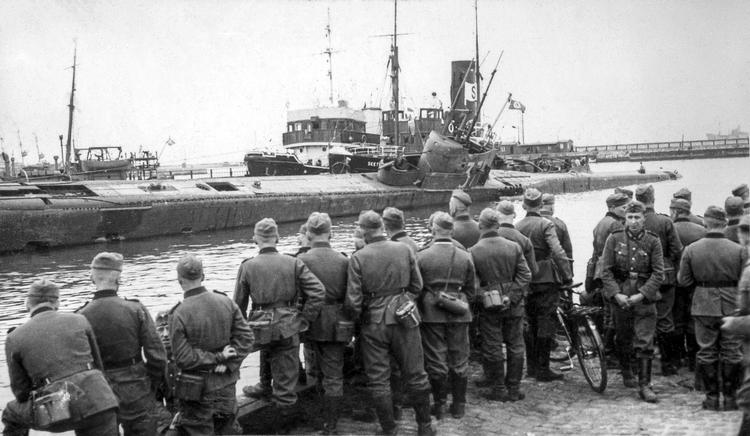 Tyske soldater så glade til, da den britiske mineubåd 'Seal' med stærk slagside blev slæbt ind i havnen i Frederikshavn. Her blev den tømt for vand og så slæbt til Kiel for at blive repareret. Foto fra bogen.  