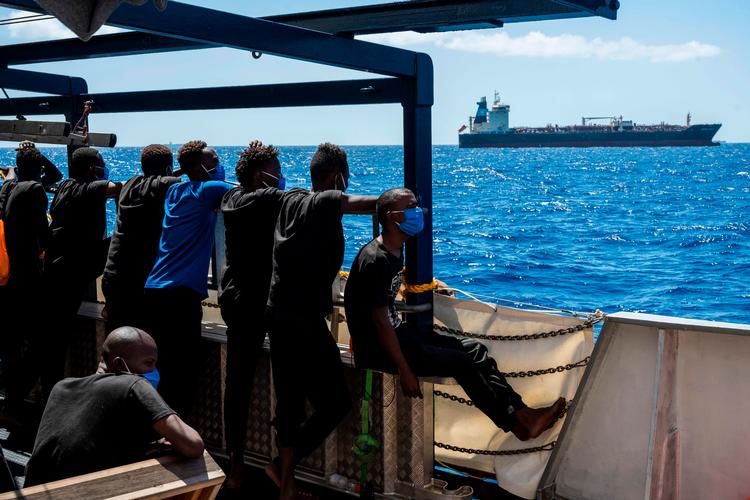 Migranter om bord på ngo-skibet 'Sea-Watch' kigger over mod 'Maersk Etienne'. Foto: Thomas Lohnes/Ritzau Scanpix
