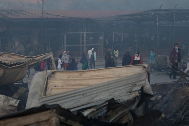 Telte, kontorer og beboelsescontainere er ødelagte af flammerne. Foto: Elias Marcou/Ritzau Scanpix