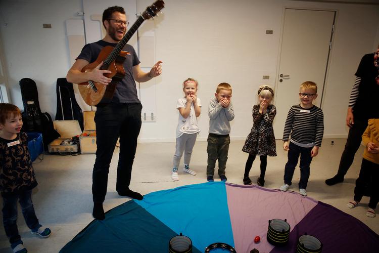Her er det musiker og musikskolelærer Jesper Heinz fra Haderslev Musikskole, der underviser et hold børnehavebørn. Men det kunne også være frivillige, lyder et forslag, der får denne kommentator til at klappe i hænderne.
  Arkivfoto Martin Lehmann