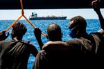 Migranter om bord på redningsskibet ser på olietankeren Maersk Etienne ud for Maltas kyst. Mærsk-skibet har huset 27 migranter i mere end en måned, fordi ingen europæiske lande ville tage i mod dem.   Foto: Thomas Lohnes/Ritzau Scanpix