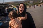 Lørdag kom det til uroligheder på Lesbos over de desperate forhold, og politiet brugte tåregas. En kvinde og en piger reagerer, efter de er blevet renset med vand for at fjerne tåregassen.  Foto: Angelos Tzortzinis/Ritzau Scanpix