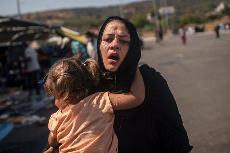 Lørdag kom det til uroligheder på Lesbos over de desperate forhold, og politiet brugte tåregas. En kvinde og en piger reagerer, efter de er blevet renset med vand for at fjerne tåregassen.  Foto: Angelos Tzortzinis/Ritzau Scanpix