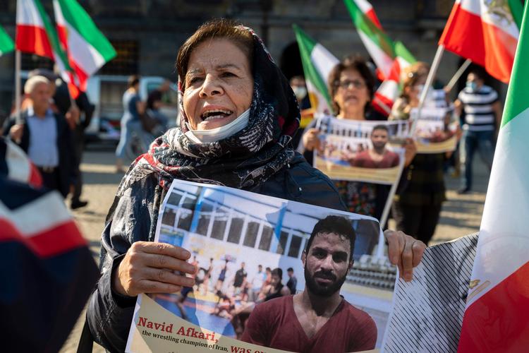 En kvinde holder portrættet af den iranske bryder Navid Afkari under en demonstration i Holland. Lørdagens Henrettelse af atleten har vækket opstand i sportsverdenen. Foto: Evert Elzinga/Ritzau Scanpix