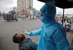 En sundhedsmedarbejder tager i denne uge en coronatest på en mand i byen  Ahmedabad. Foto: Amit Dave/Ritzau Scanpix