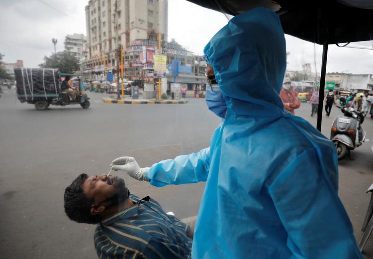 En sundhedsmedarbejder tager i denne uge en coronatest på en mand i byen  Ahmedabad. Foto: Amit Dave/Ritzau Scanpix