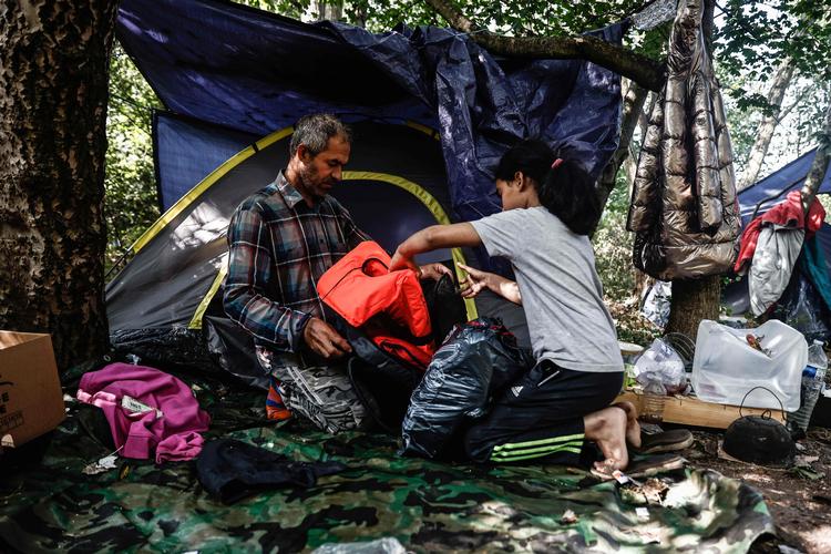  I et skovområde nær Dunkerque bor flere hundrede flygtninge og migranter, der er parat til at krydse Den Engelske Kanal i små både. Billedet fra 10. september viser den irakiske migrant Falah og hans datter Arwa på 10 år. Foto: Sameer Al-doumy/Ritzau Scanpix