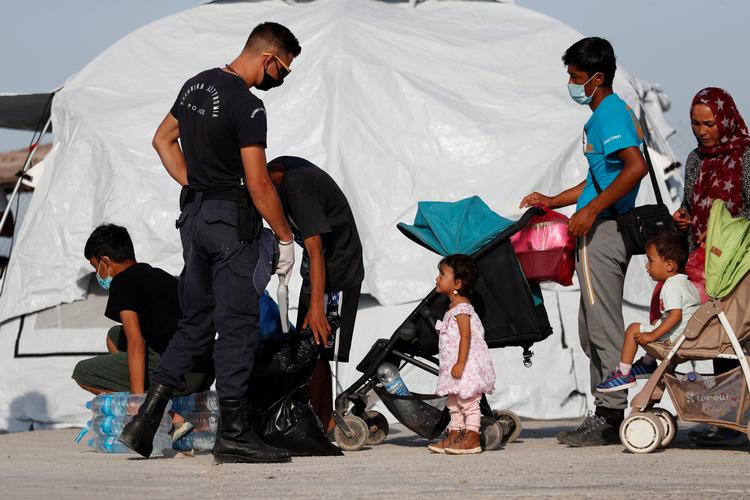 Flyttet. En græsk politimand tjekker nogle af de tidligere Moria-beboere, som nu er flyttet til en stor nødlejr på Lesbos. Foto: Yara Nardi/Ritzau Scanpix