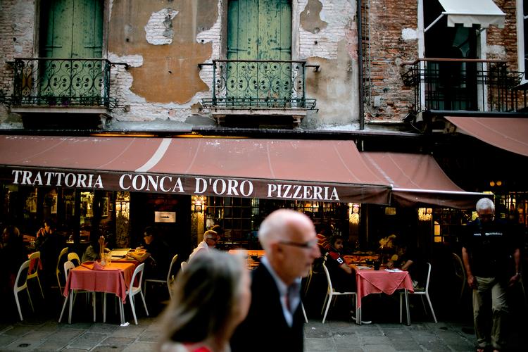 Måske er det Italien, du længes mod? Her er der udendørsservering i Venedig. Arkivfoto Joachim Adrian