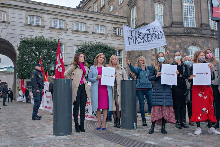 En insisterende demonstrant, som var imod mundbind, blev ophidset over synet af de mange kvinder, der bar mundbind, og blandede sig i happeningen. Det var en af årsagerne til, at kvinderne senere rykkede ind foran Christianborgs stentrappe. Foto: Miriam Dalsgaard/POLFOTO