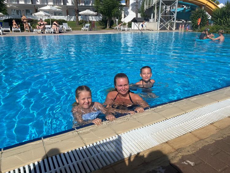 Mette Fragtrup nyder en af hotellets tre svømmepøler på Rhodos sammen med datteren Andrea (th.) og niecen Thea. Resten af storfamilien på 19 var spredt for alle vinde. Foto: Privatfoto