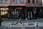 En kvinde iført mundbind spadserer forbi lukkede barer i Thessaloniki i Grækenland. Grækenland er et af de europæiske lande, der lukker helt eller delvist ned i den kommende uge i et forsøg på at dæmme op for coronavirus.
    Foto: Sakis Mitrolidis/Ritzau Scanpix