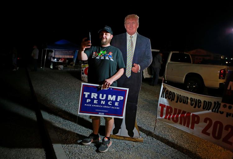 En vælger i Nevada står ved siden af et papskilt af præsident Donald Trump. Foto: Ronda Churchill/Ritzau Scanpix