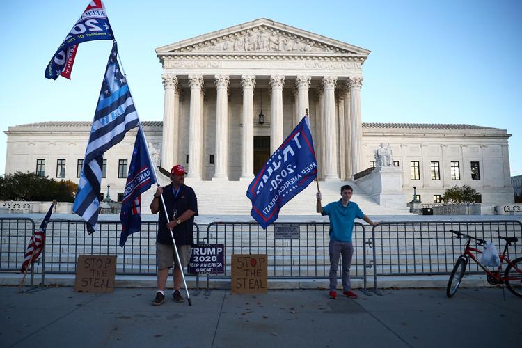 Højesteret i hovedstaden Washington D.C. i USA. Foran står to Trump-tilhængere på dagen, hvor retten skulle lytte til argumenter for at nedlægge obamacare. Foto: Hannah Mckay/Ritzau Scanpix