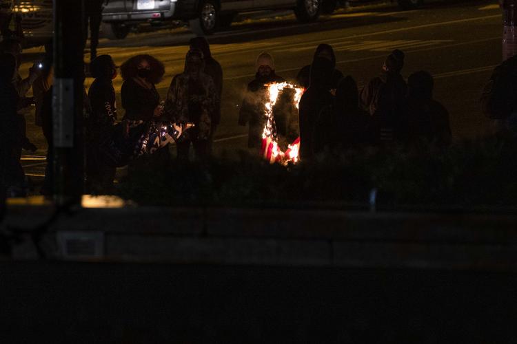 Medlemmer af Antifa har stukket et amerikansk flag i brand under urolighederne i Washington. Foto: Samuel Corum/Ritzau Scanpix