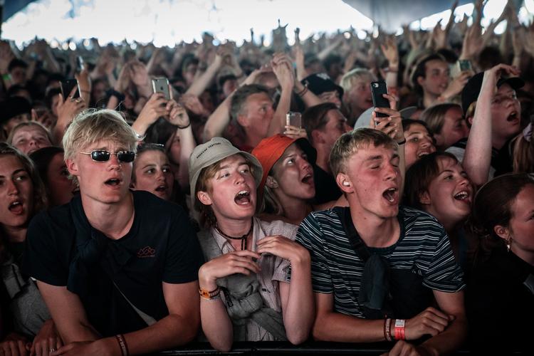 Fællessang på Roskilde Festival 2019. I år blev festivalen aflyst på grund af pandemien. Men hvad med næste år? Kan en effektiv vaccine åbne orange scene? Foto: Jens Hartmann Schmidt/POLFOTO