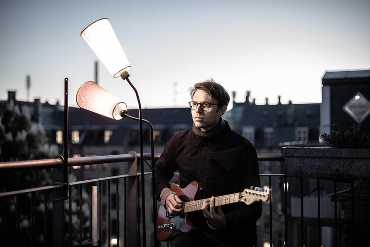 I forne tider stod bejleren på jorden og sang serenader til sin udkårne på balkonen. Mikkel Ploug sidder på altanen og spiller for hele verden – med umådelig kærlighed til musikken. Foto: Thomas Rungstrøm