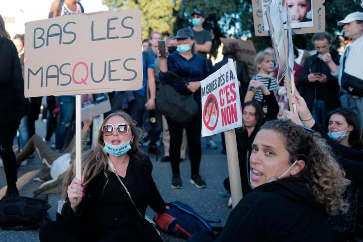 Fjern maskerne, står der på skiltet under en demonstration i Nice. Polemikken om masker er med til at fremme konspirationsteorierne i Frankrig. Foto: Valery Hache/Ritzau Scanpix