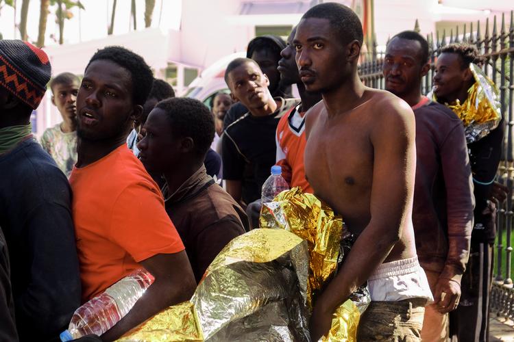 Ankommet. En gruppe afrikanere er nået i land på stranden ved Maspalomas på Gran Canaria efter den farlige tur i en lille træbåd over havet. 

 Foto: Javier Bauluz/Ritzau Scanpix